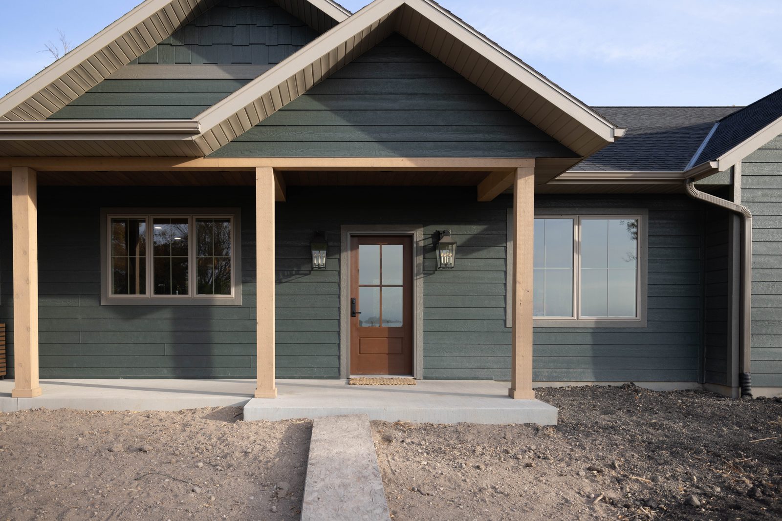LP Diamond Kote siding in dark green with covered front porch on custom home in Wendell, MN, supplied by Lakeside Lumber