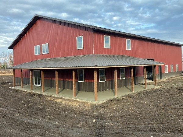Red post-frame pole barn shop with wraparound covered porch in Underwood, MN, built with materials from Lakeside Lumber