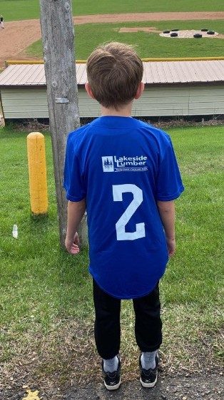 Young player wearing a Prairie River Baseball Cubs uniform sponsored by Lakeside Lumber